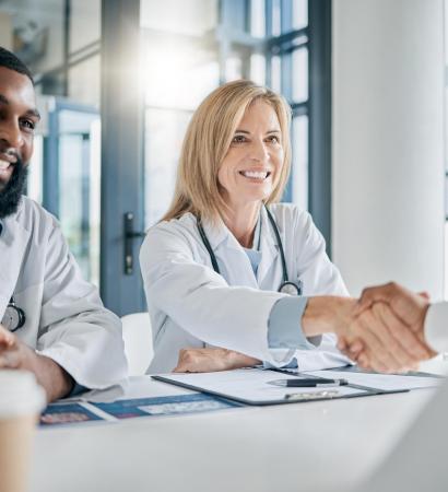 Handshake, partnership or happy doctors in a meeting after successful medical surgery or reaching h.